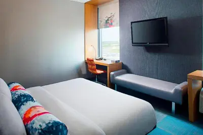 a hotel room with two beds and a flat screen tv at Aloft Philadelphia Airport in Philadelphia