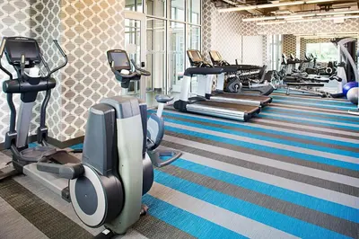 a gym with rows of treadmills and cardio machines at Aloft Philadelphia Airport in Philadelphia