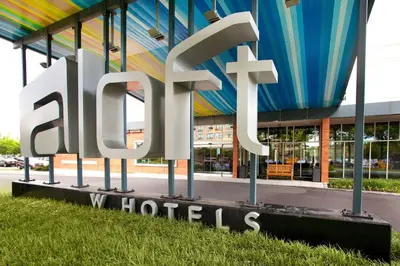 a large metal sign that reads spa hotels in front of a building at Aloft Philadelphia Airport in Philadelphia