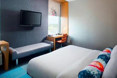 a hotel room with two beds and a flat screen tv at Aloft Philadelphia Airport in Philadelphia