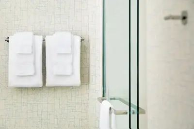a bathroom with white towels hanging on a wall at Holiday Inn Express - Wilmington North - Brandywine by IHG in Wilmington