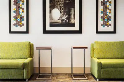 two green chairs in a room with pictures on the wall at Holiday Inn Express - Wilmington North - Brandywine by IHG in Wilmington