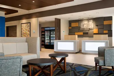 a lobby with two chairs and a couch and tables at Holiday Inn Express - Wilmington North - Brandywine by IHG in Wilmington