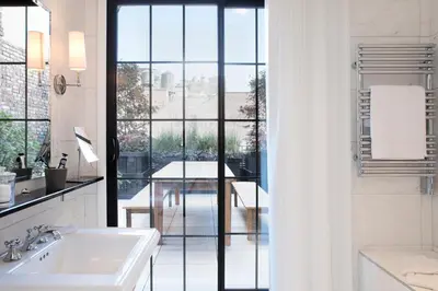 a bathroom with a sink and a large window at The Broome in New York