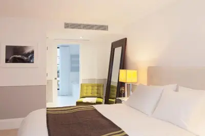 a bedroom with a white bed and a green chair at The Broome in New York
