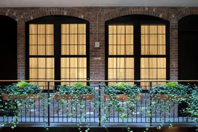 a group of windows in a brick building with potted plants at The Broome in New York