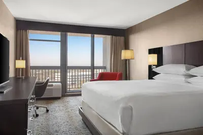 a hotel room with a large bed and a desk and window at Delta Hotels by Marriott Somerset in Somerset
