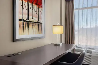 a desk in a hotel room with a lamp and a window at Delta Hotels by Marriott Somerset in Somerset