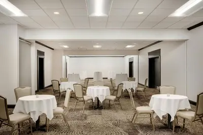a room with white tables and chairs and a room with a wall at Delta Hotels by Marriott Somerset in Somerset