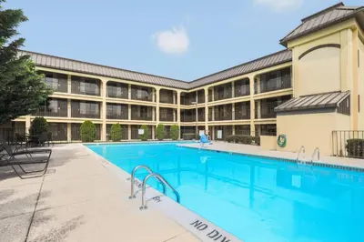 an exterior view of a large building with a swimming pool at Days Inn by Wyndham Newark Wilmington in Newark