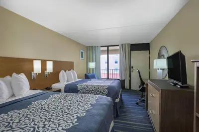 a hotel room with two beds and a flat screen tv at Days Inn by Wyndham Newark Wilmington in Newark