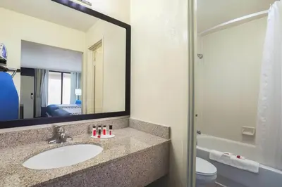 a bathroom with a sink and a mirror at Days Inn by Wyndham Newark Wilmington in Newark