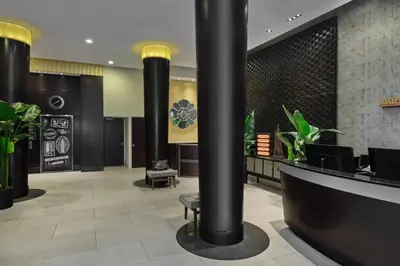 a lobby with black columns and plants at Marriott Vacation Club®, New York City  in New York