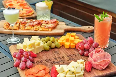 a table topped with cheese and fruit and a pizza at Marriott Vacation Club®, New York City  in New York