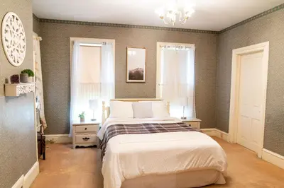 a bedroom with a large bed and a chandelier at CHARMING EXECUTIVE VICTORIAN MANSION w/ FREE PARKING - near Bucknell in Milton