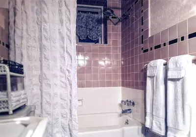 a bathroom with a tub and a shower curtain at CHARMING EXECUTIVE VICTORIAN MANSION w/ FREE PARKING - near Bucknell in Milton