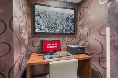 a computer on a desk with a sign that reads free wifi all hours at Red Roof Inn Fairfield in Fairfield