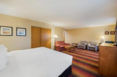 a hotel room with a bed and a living room at Red Roof Inn Fairfield in Fairfield