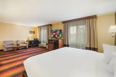 a hotel room with a bed and a living room at Red Roof Inn Fairfield in Fairfield