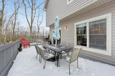 a patio with a table and chairs in the snow at Northridge 199 in Tannersville