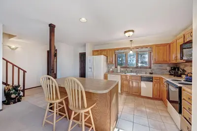 a kitchen with wooden cabinets and a island with stools at Camelback 302 in Tannersville