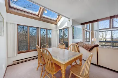 a dining room with a table and chairs and windows at Camelback 302 in Tannersville