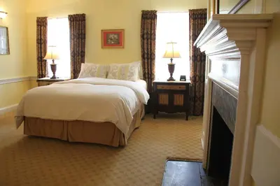 a hotel room with a bed and two windows at Morris House Hotel in Philadelphia