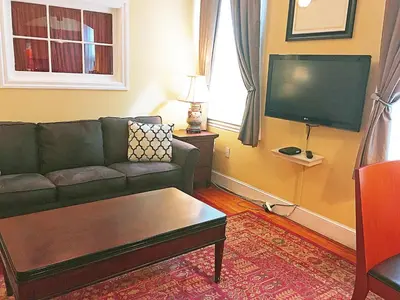 a living room with a couch and a flat screen tv at Morris House Hotel in Philadelphia