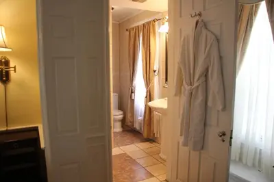 a bathroom with a toilet and a robe hanging on a door at Morris House Hotel in Philadelphia