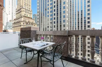 a table and chairs on a balcony with buildings at Hotel 57 in New York