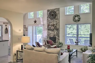 a living room with a couch and a stone fireplace at Spacious Home with Deck, Grill and Delaware River View in Callicoon