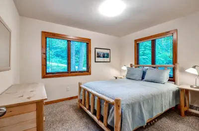 a bedroom with a bed and two windows at Waterfront Highland Lake Home with Deck and Dock in Highland Lakes