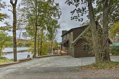 a house with a large driveway next to a lake at Waterfront Highland Lake Home with Deck and Dock in Highland Lakes