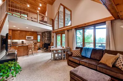 a living room with a couch and a kitchen at Waterfront Highland Lake Home with Deck and Dock in Highland Lakes