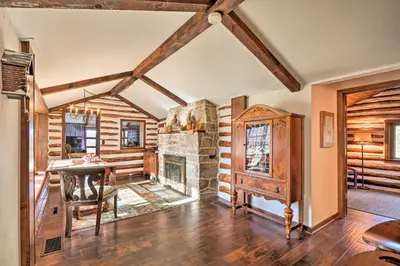 a living room with a fireplace and a table at Macungie Cabin with Fireplace Near Bear Creek Skiing in Macungie