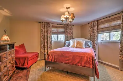 a bedroom with a bed and a red chair at Macungie Cabin with Fireplace Near Bear Creek Skiing in Macungie