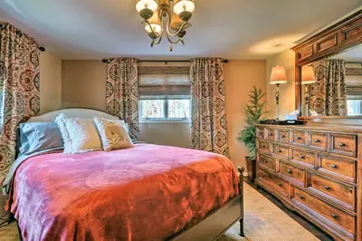 a bedroom with a large bed and a dresser at Macungie Cabin with Fireplace Near Bear Creek Skiing in Macungie
