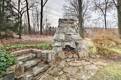 an old stone structure in a park with trees at Macungie Cabin with Fireplace Near Bear Creek Skiing in Macungie