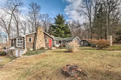 a house with a stone chimney on a yard at Macungie Cabin with Fireplace Near Bear Creek Skiing in Macungie