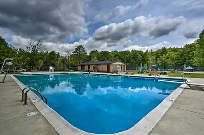 a large blue swimming pool in front of a house at Deck and Fire Pit Pocono Lake Home Near Skiing! in Pocono Lake