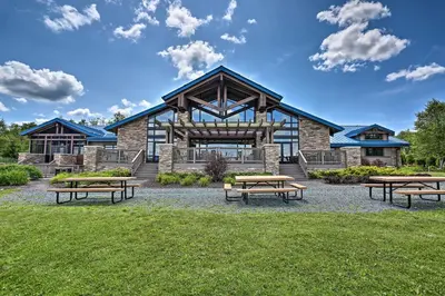 a group of picnic tables in front of a building at Deck and Fire Pit Pocono Lake Home Near Skiing! in Pocono Lake