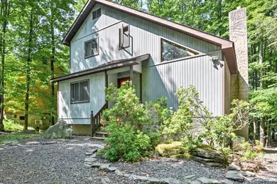 a house in the woods with a driveway at Peaceful Hamlin Home with Lake Access at The Hideout in Hamlin