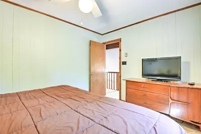 a bedroom with a bed and a tv on a dresser at Peaceful Hamlin Home with Lake Access at The Hideout in Hamlin