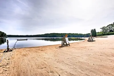 a beach with two signs on the shore of a lake at Peaceful Hamlin Home with Lake Access at The Hideout in Hamlin