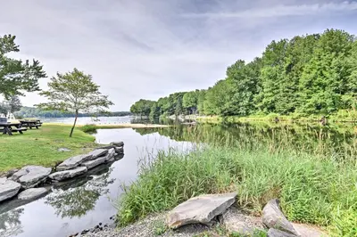 a view of a river with a picnic table at Peaceful Hamlin Home with Lake Access at The Hideout in Hamlin