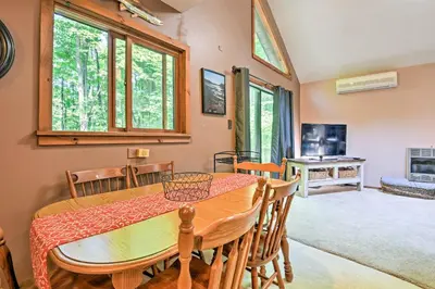 a dining room with a table and chairs and windows at Peaceful Hamlin Home with Lake Access at The Hideout in Hamlin