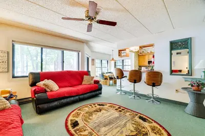 a living room with a red couch and a table at 1 Mi to Big Boulder Lakefront Unit with Pool Access in Lake Harmony