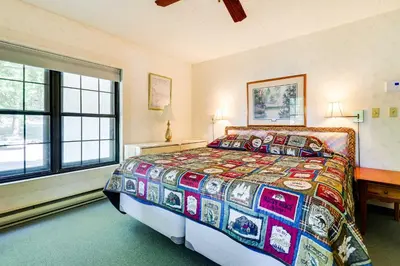 a bedroom with a bed with a colorful quilt at 1 Mi to Big Boulder Lakefront Unit with Pool Access in Lake Harmony