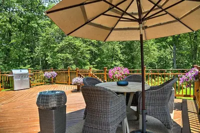 a table and chairs with an umbrella on a deck at Colonial-Style Warwick Retreat - 1 Hour to NYC! in Warwick
