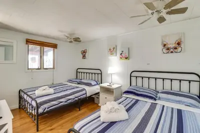 a bedroom with two beds and a ceiling fan at Happy Place by the Lake with Fire Pit Walk to Beach in Pocono Lake